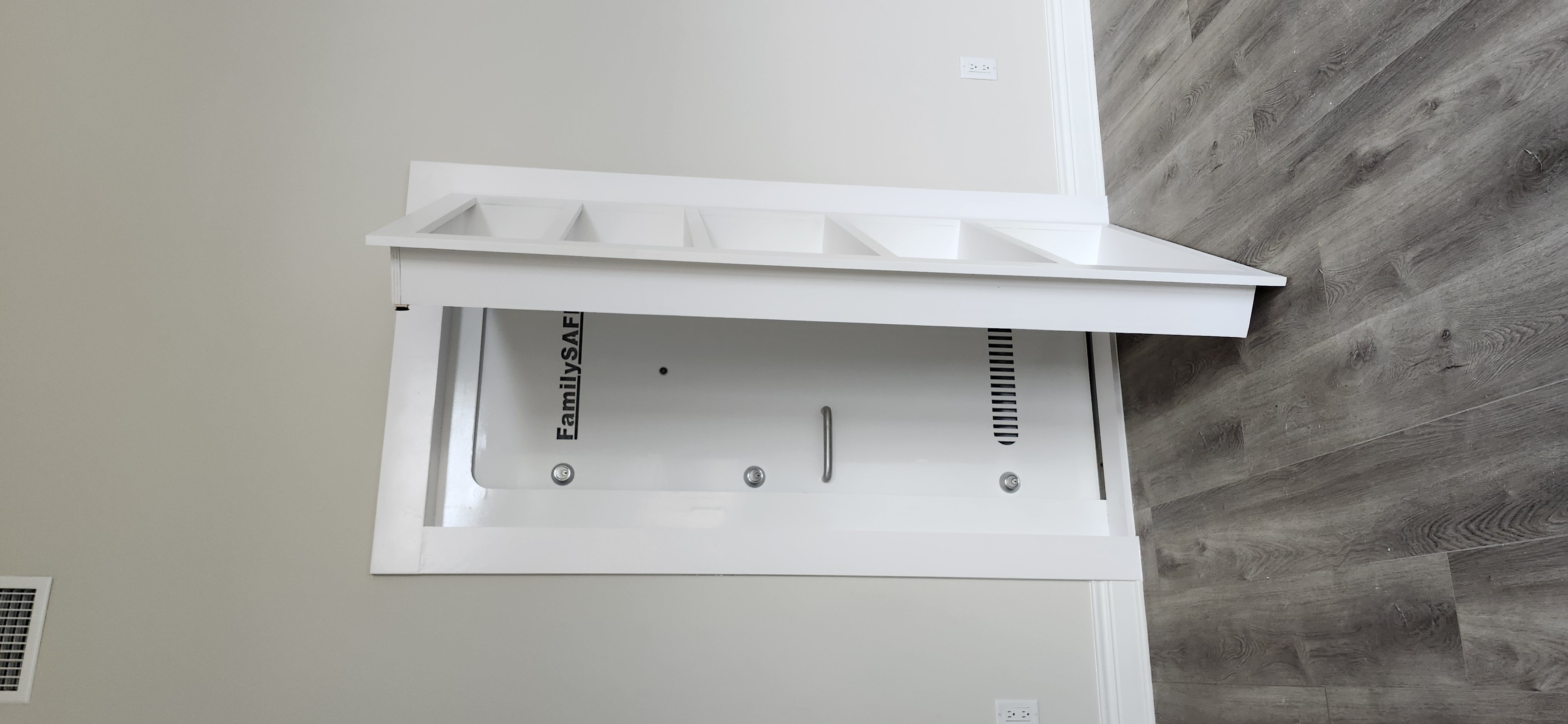 Hidden bookcase door open revealing FamilySafe storm shelter