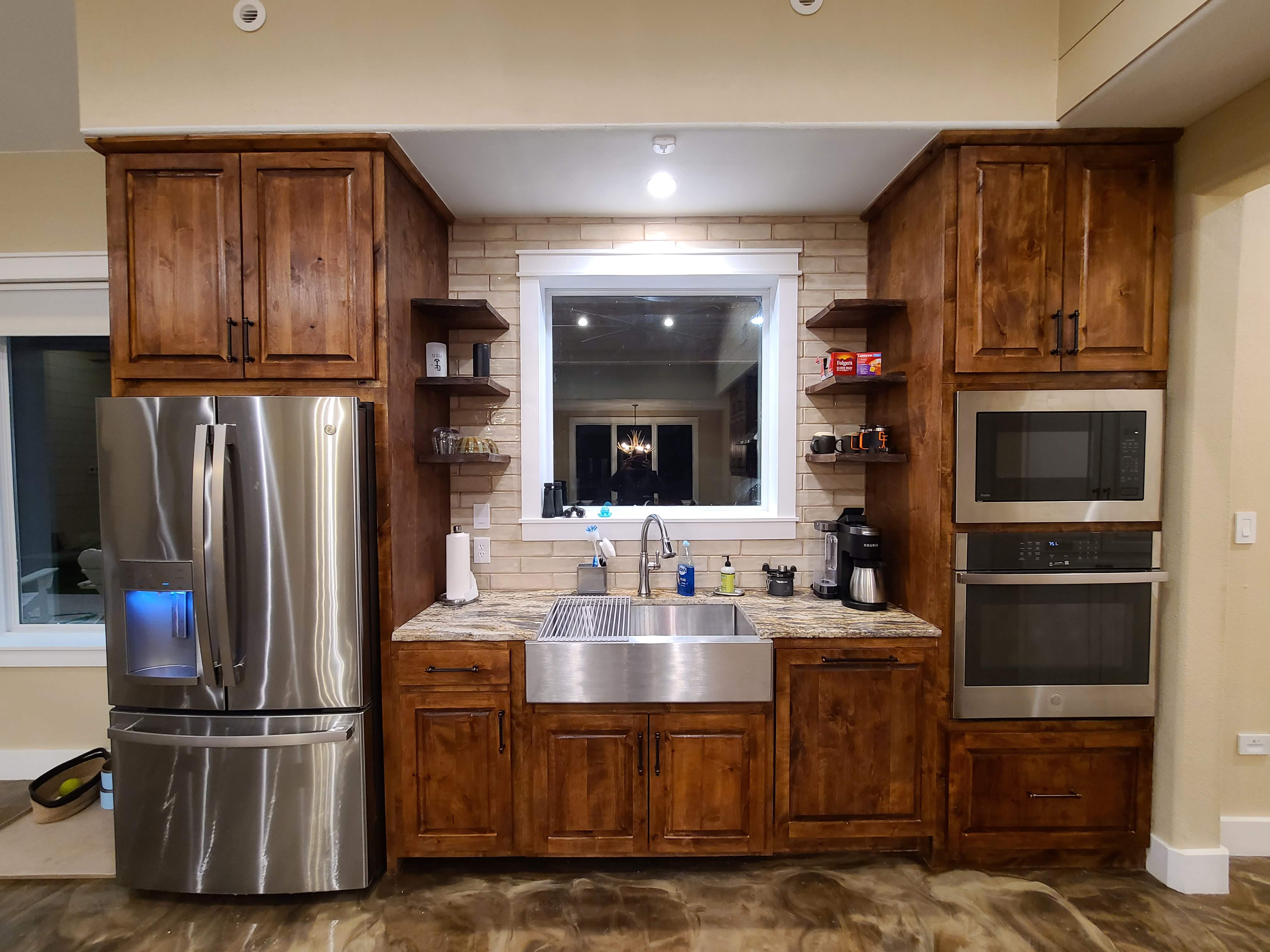 Farmhouse sink wall open shelving double oven knotty alder cabinets