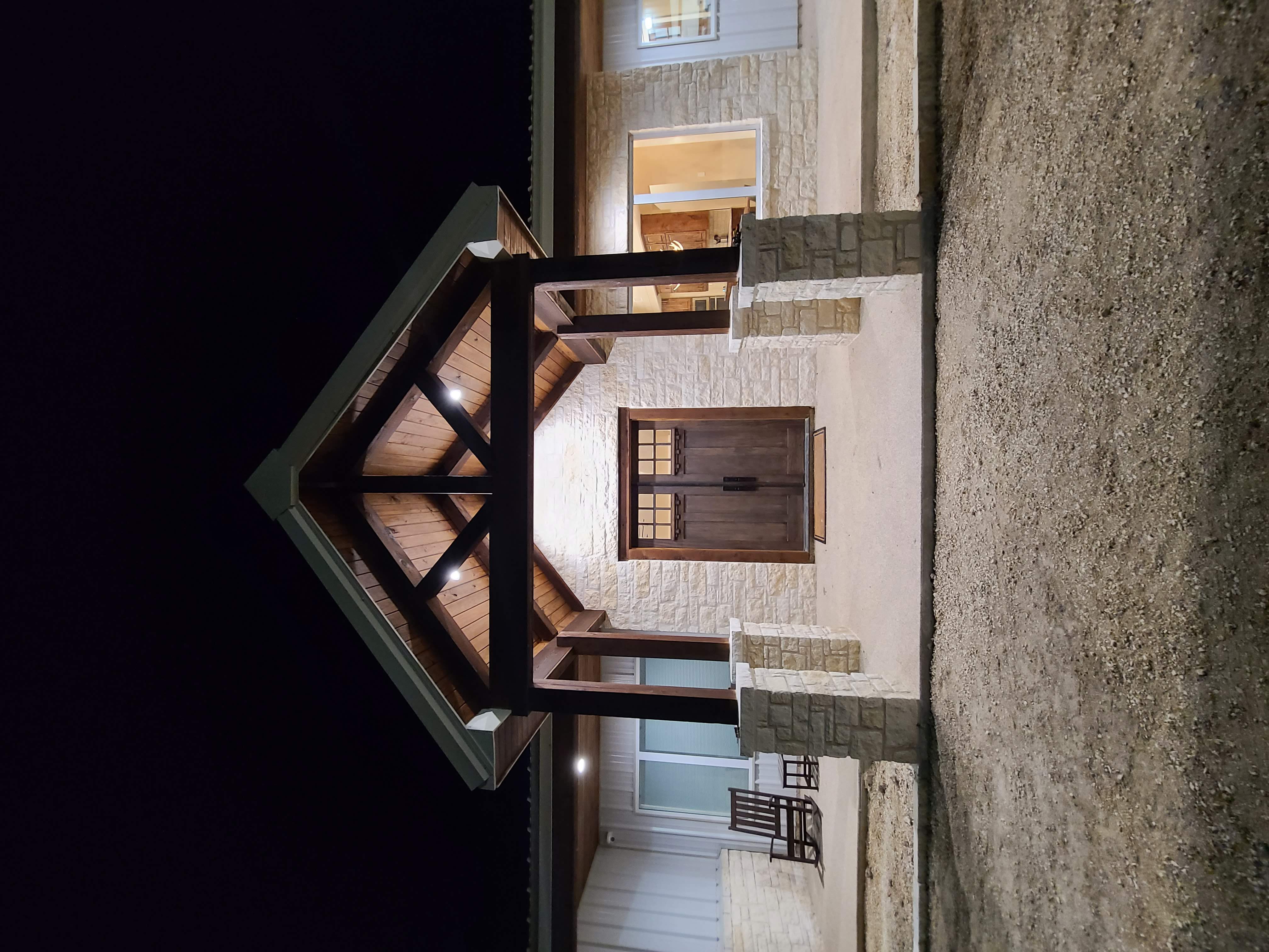 Custom timber frame entry double wood doors limestone night