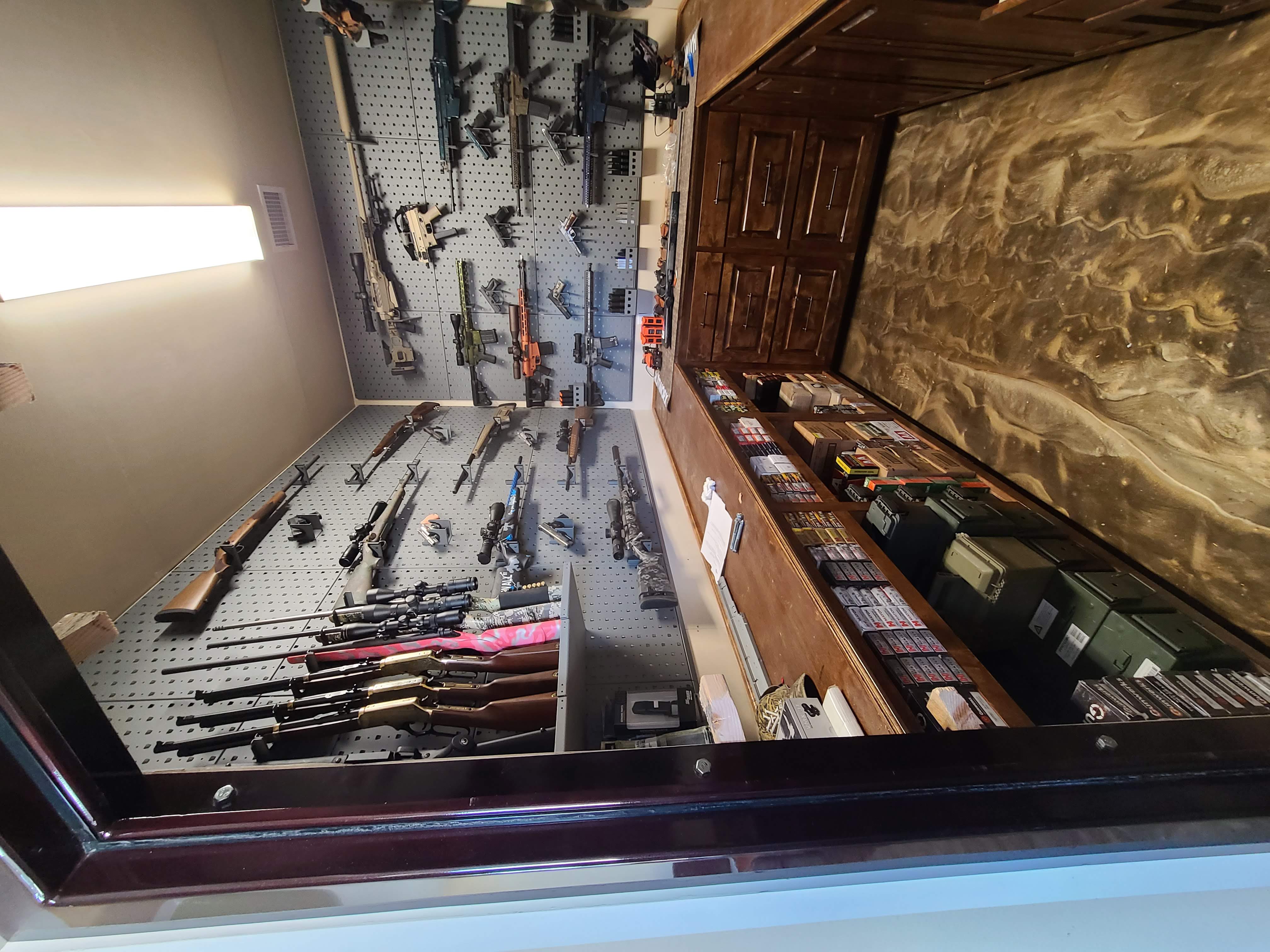 Custom gun room built-in workbench cabinets pegboard epoxy floor