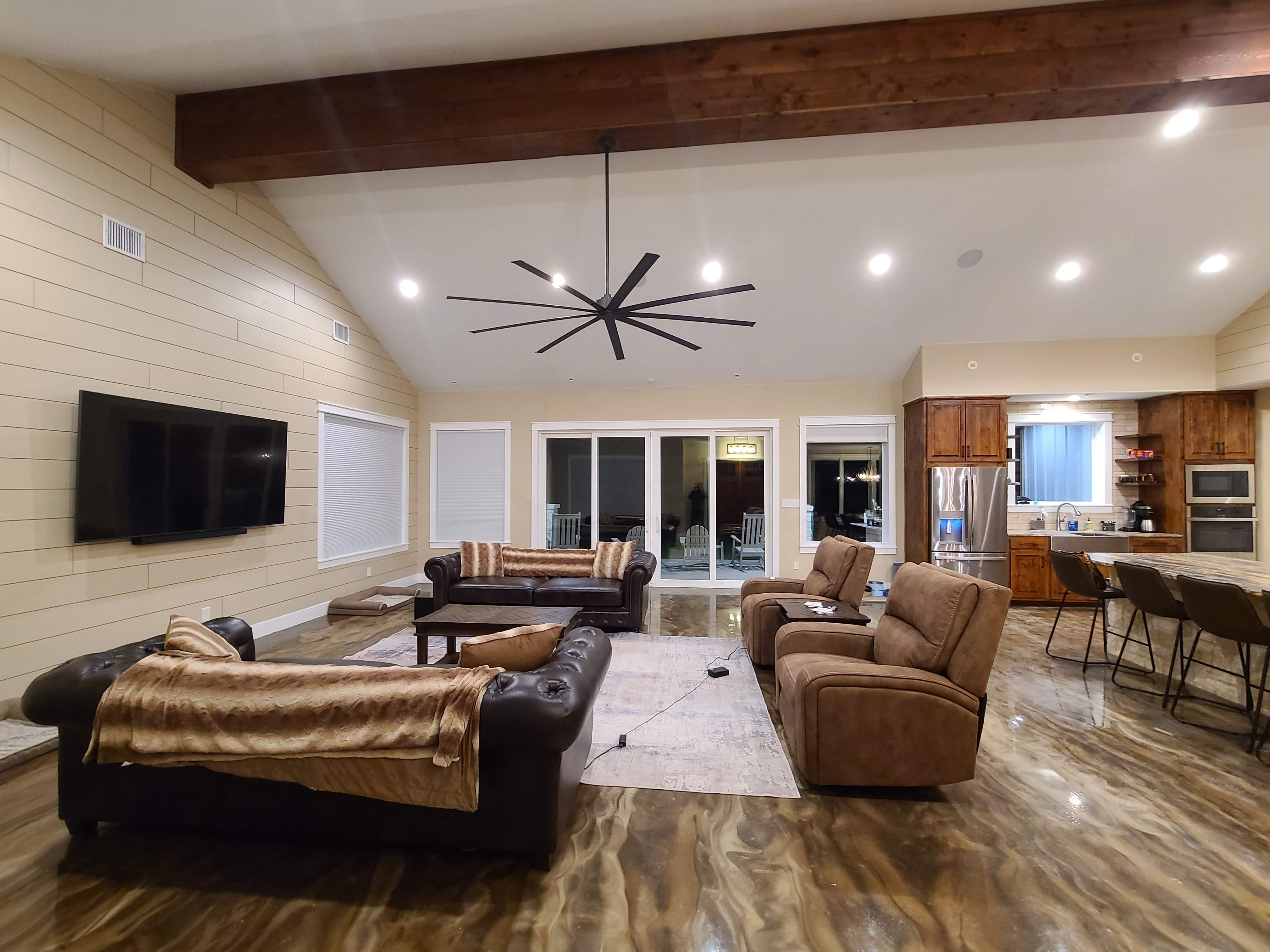 Living room shiplap wall view to kitchen and back porch doors