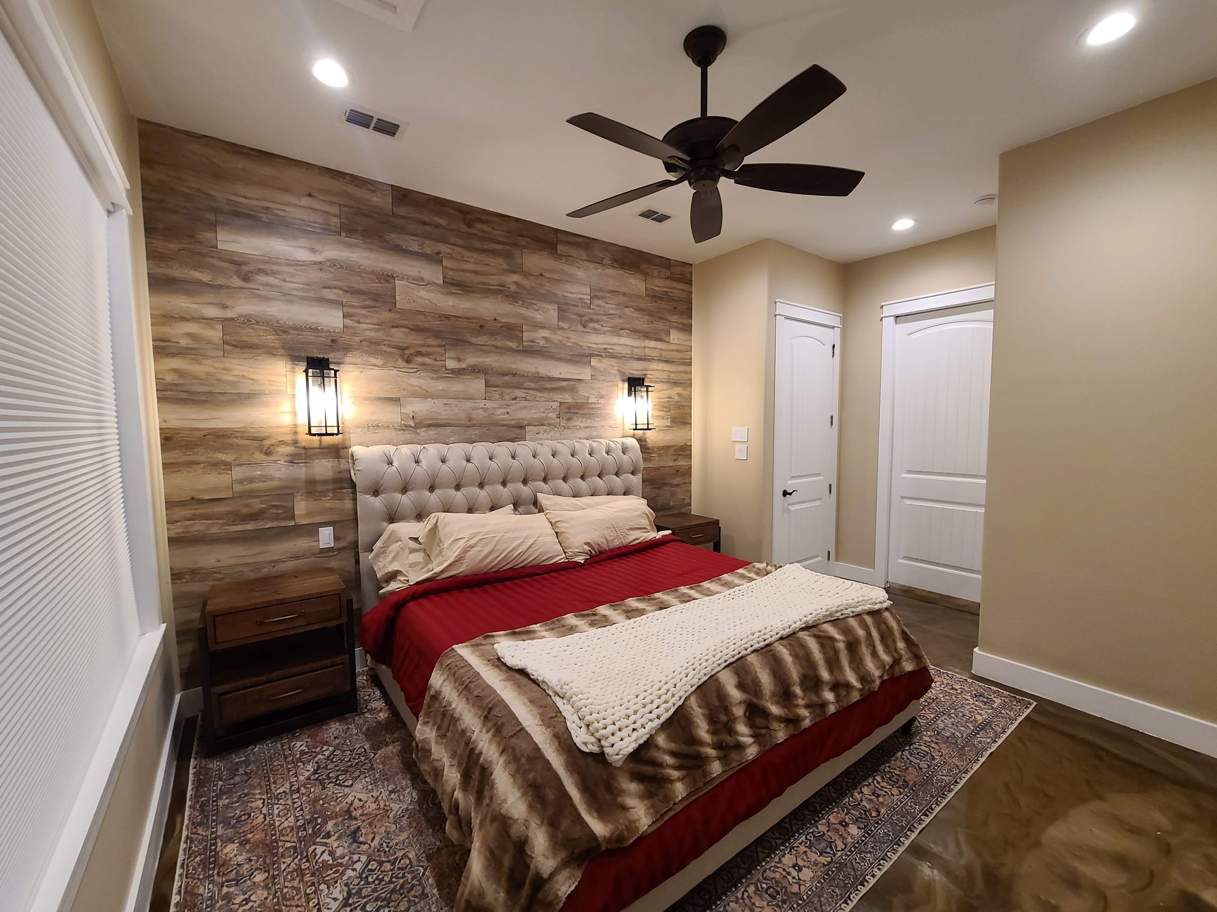 Master bedroom wood tile accent wall sconce lighting epoxy floor